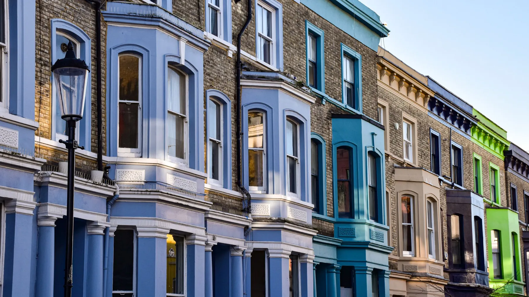 Row of colourful London terraced houses with bay windows